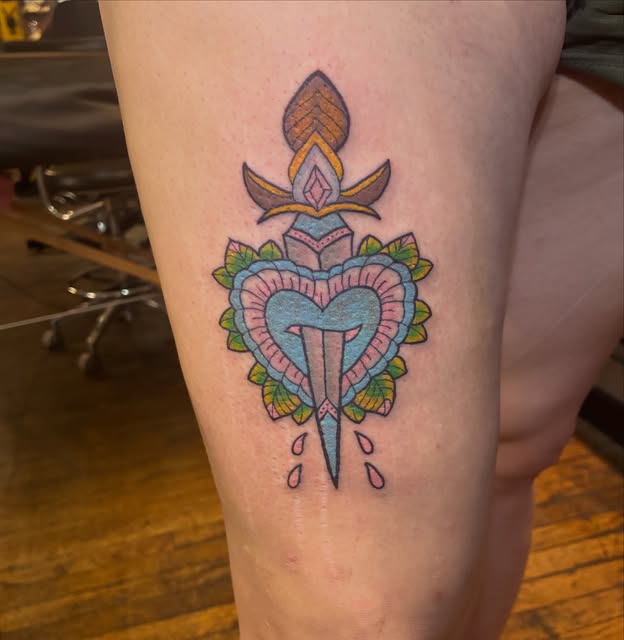 Traditional dagger and heart thigh tattoo